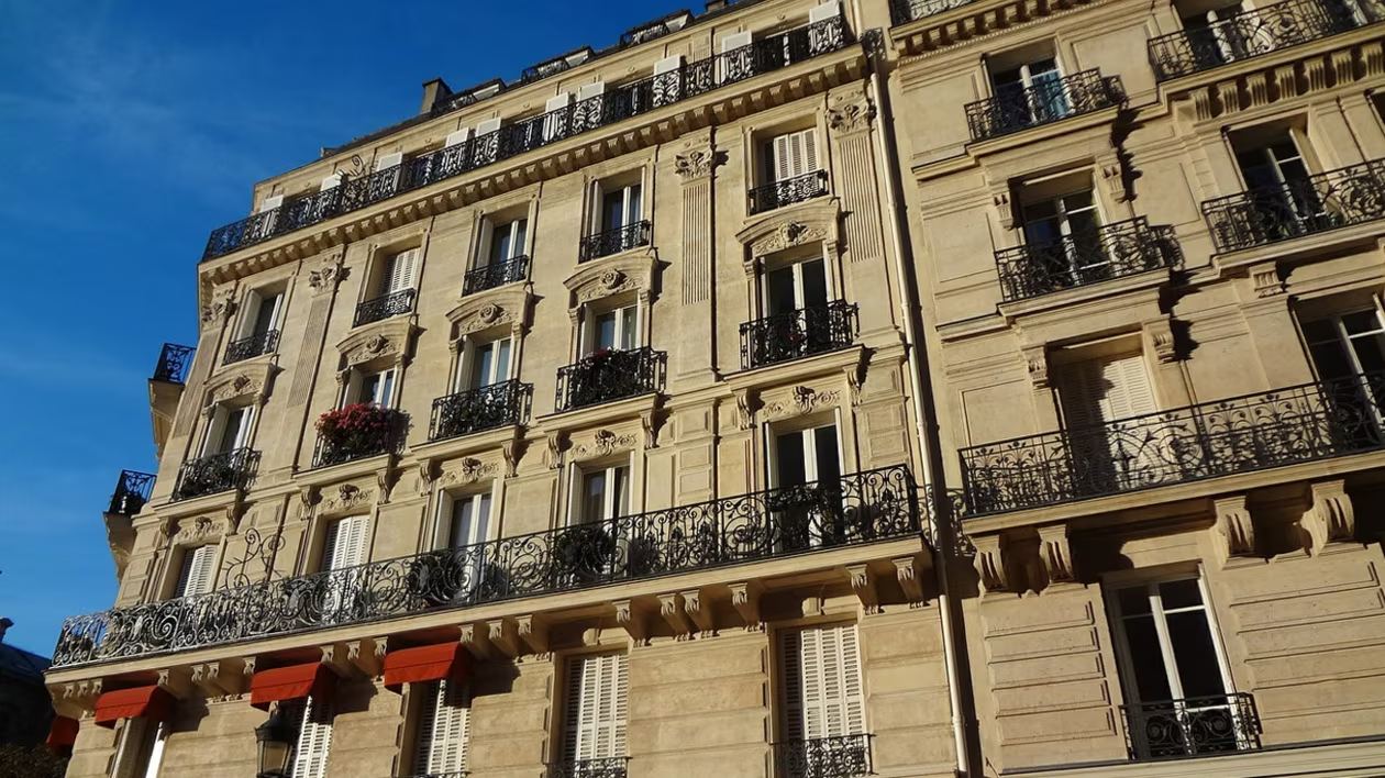 Immeuble en pierre avec balcons en fer forgé à Agen